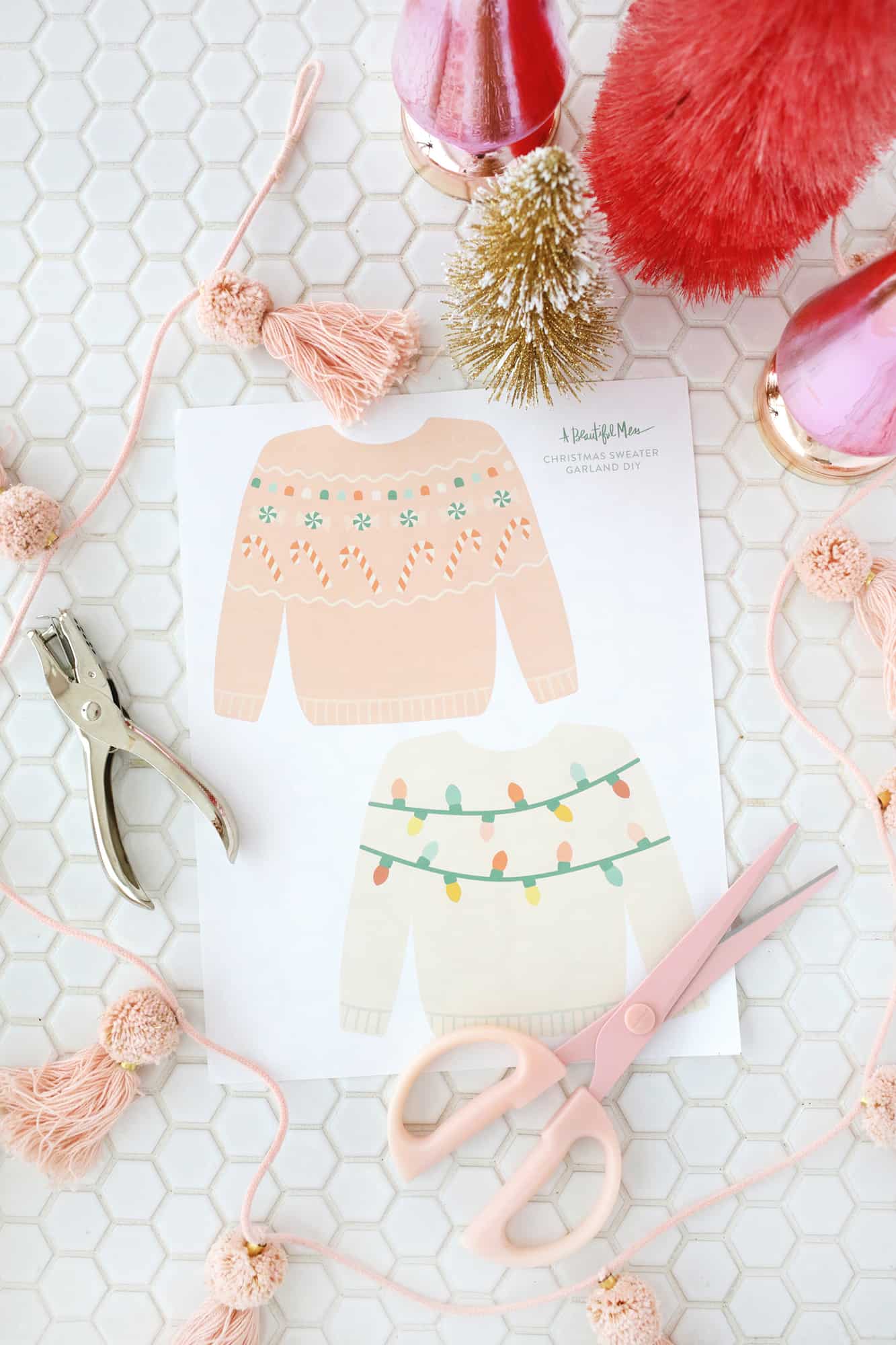 Paper Christmas sweaters about to be cut out with scissors