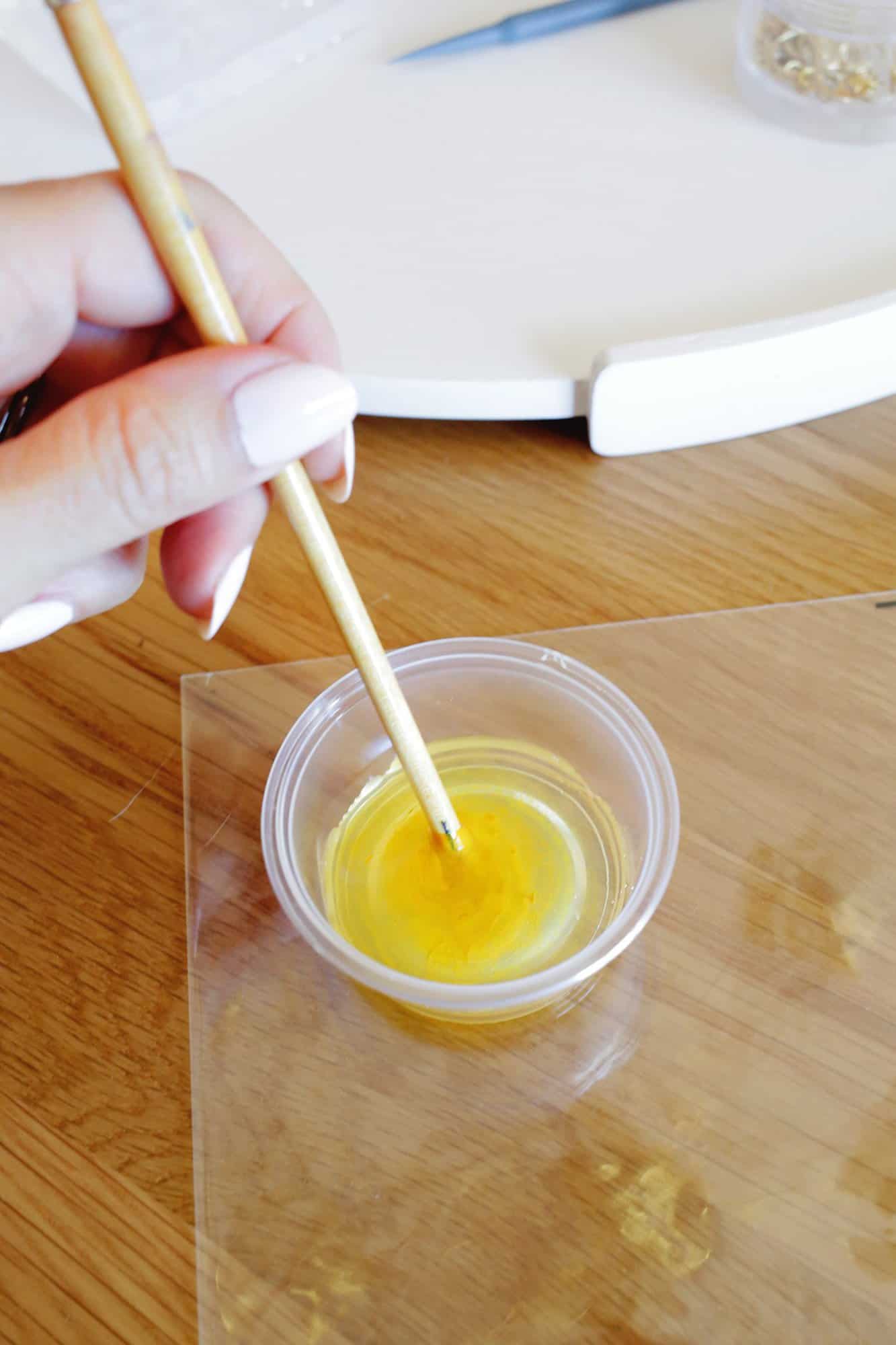 mixing paint into epoxy in a small cup